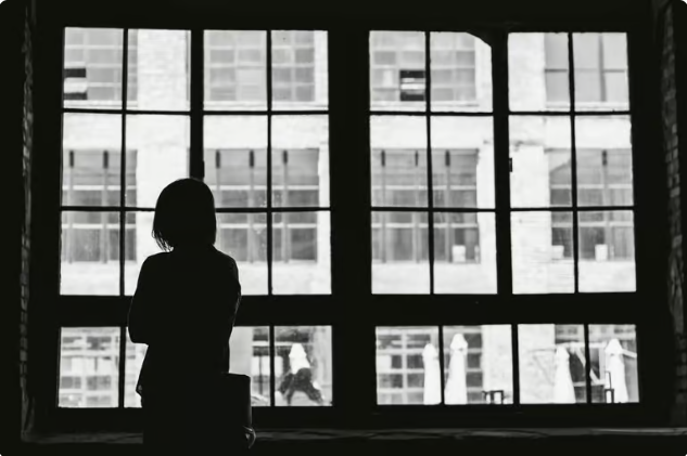 ThePlacesWeGoTo Black-and-white photo with a silhouette of a girl staring out a window towards facing windows